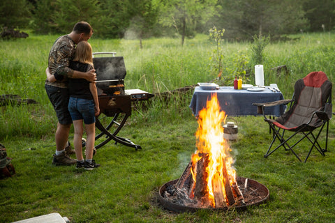 Couple Standing By Pit Boss Grill and Campfire