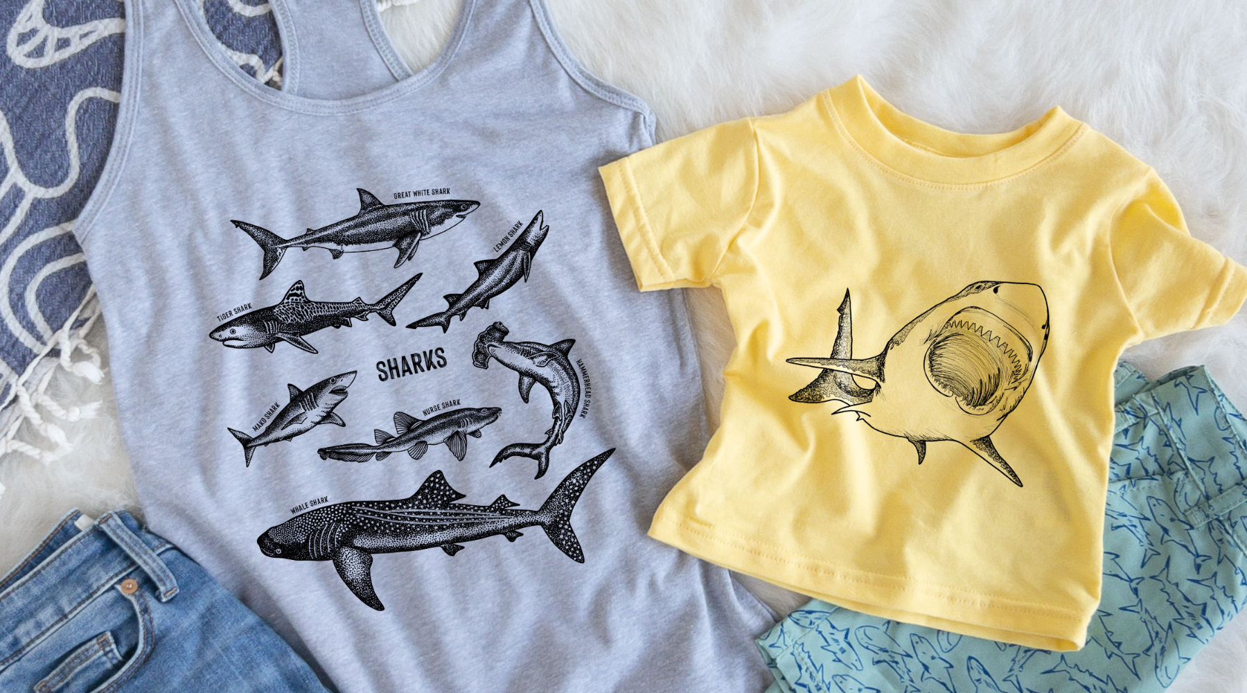 Flat lay of two shirts that have shark graphics on them 