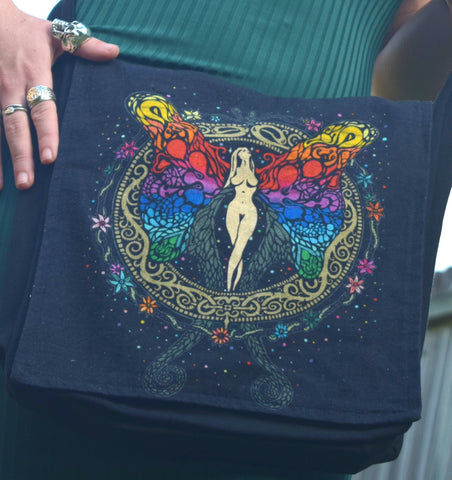 Person holding a shoulder bag with a goddess, rainbow fairy on the front
