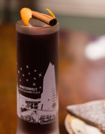 Pomegranate Mulled Wine cocktail with citrus peel and cinnamon garnish