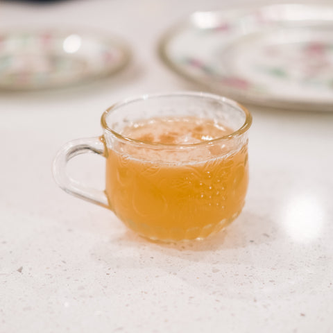 Punch au rhum à l'ananas épicé dans une tasse à punch sur une table blanche