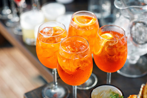 Photo de quatre cocktails apéritifs garnis de fruits frais