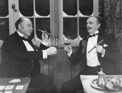 Photo of two gentlemen enjoying cigars and digestifs