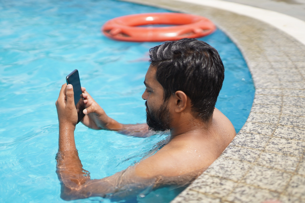 man on phone in pool