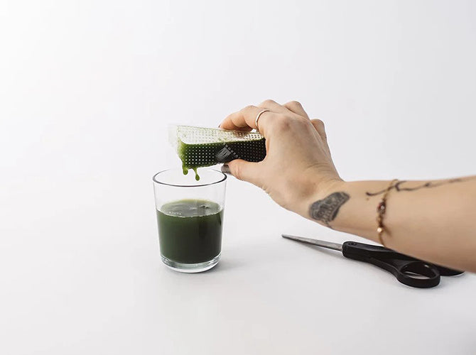 Wheatgrass juice being poured into a glass