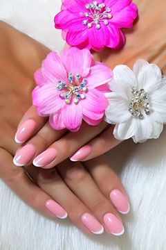 Woman's hands with flower designs on pink and white powder French manicure nails