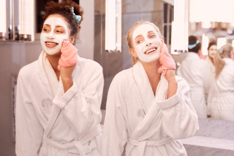 dwie kobiety zmywają maseczki kosmetyczne z twarzy