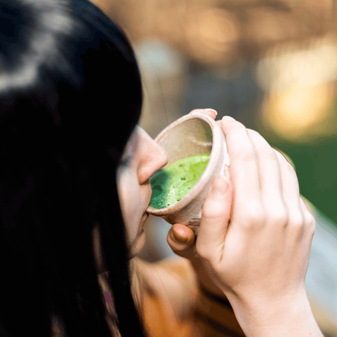 kobieta pije zielony płyn