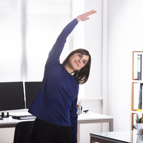 kobieta gimnastykuje się w biurze