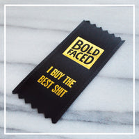 small black award ribbon that features a gold Boldfaced logo as well as the words I buy the best shit. Every order includes this free ribbon.