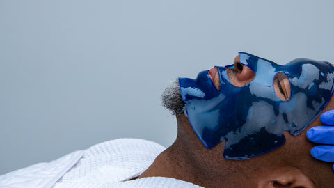 Male client being treated with a copper infused, hyaluronic repair face masque