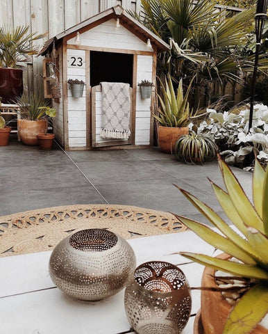 Bohemian outdoor living area with natural materials, summerhouse and tropical planting