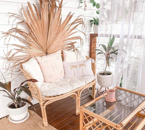 XL dried fan palm wall hanging with rattan furniture creates retro, bohemian aesthetic