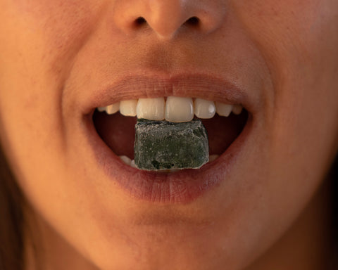 Mujer con un cubo de espirulina congelada en su boca