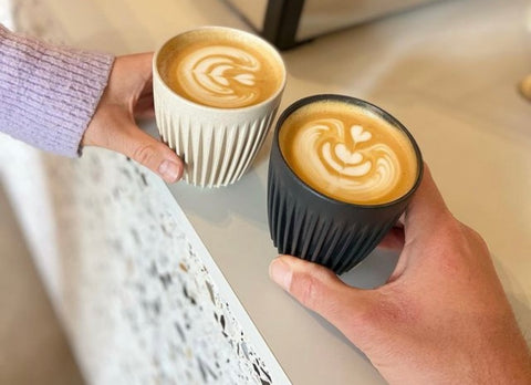 2 hands holding a textured coffee cup