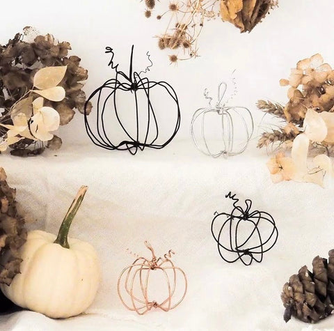 An assortment of wire pumpkins in black, silver and copper  