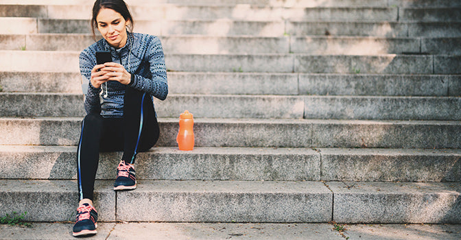 woman sitting outside with her phone