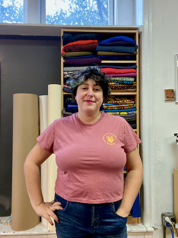 Ruby stands in her studio modeling a mauve Arm Candy Tee with short sleeves. The fit is somewhat snug across the bust, but still a bit loose around the waist.