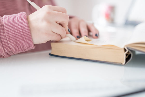 Allison Murphy, owner of The ABC Market, measuring and folding pages of a recycled book to create a custom folded piece of book art