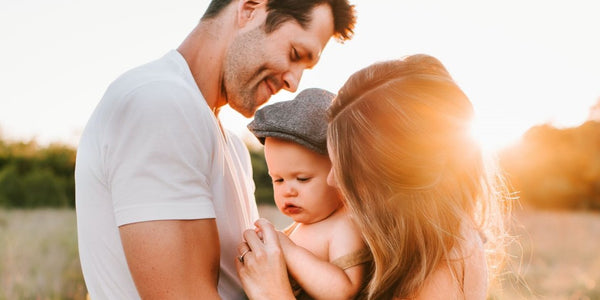 A loving couple cradling their precious baby in a beautiful field. Cherishing the joy of parenthood amidst nature's embrace.