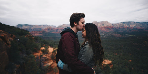 A romantic couple sharing a kiss in Sedona, Arizona, surrounded by stunning natural beauty.