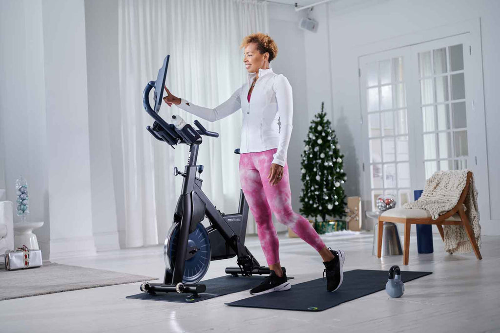 Photo of a woman selecting her workout on her new myx bike