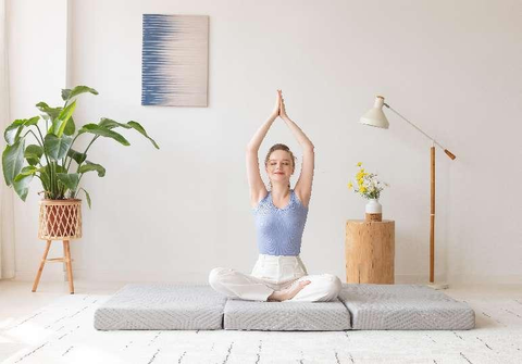 A woman practicing yoga on a tri-fold mat