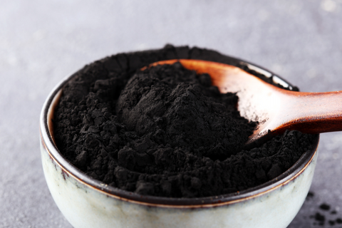 Activated charcoal on a spoon in a bowl