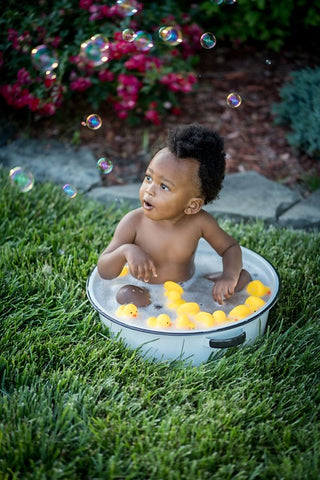 Baby in a white dish and bubbles floating