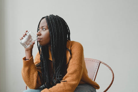 Photo by Dziana Hasanbekava: https://www.pexels.com/photo/thoughtful-young-african-american-female-sitting-on-chair-and-drinking-water-7275445/