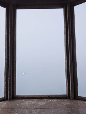 A window looking out into the bleak sea mist