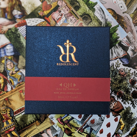 The packaging for QH with the Redolescent blue box and a red band across the middle with bronze ink for the text.