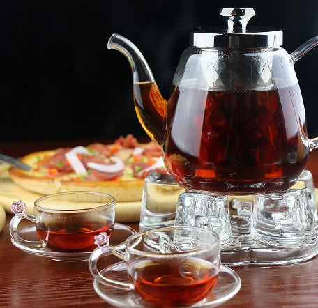 carafe de thé noir avec des tasses remplies de thé noir
