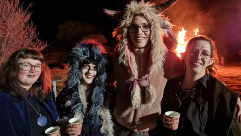 A group of young adults dressed in celtic costumes in front of a brightly burnign fire at Small Acres Cyder's Winter Wassail event.