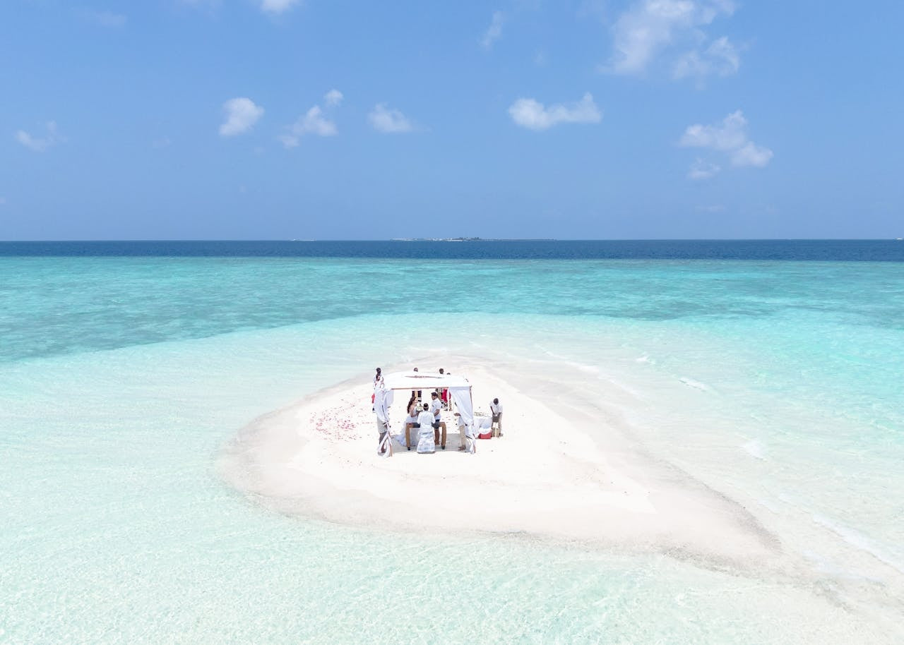 Up high view of a wedding on a sand bar in tropical waters.