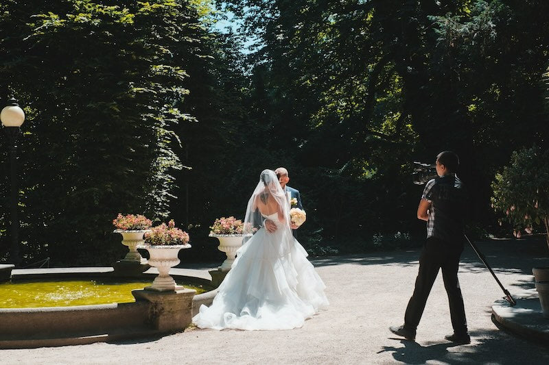 Wedding Couple infront of camera outdoors in a garden.