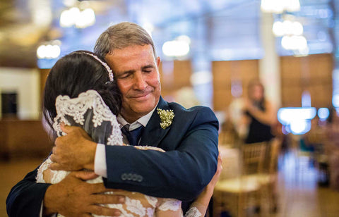 Father of the bride hugging daughter