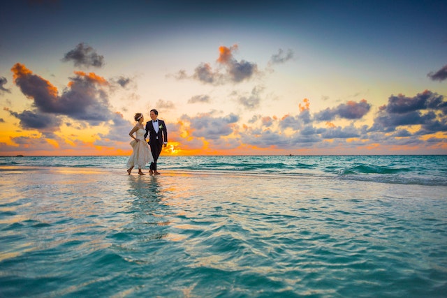 Wedding couple walking on beach sandbar