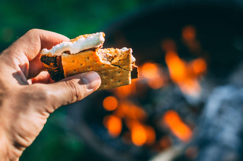 Having a s'more over the fire.