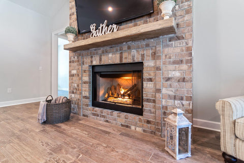 A beautiful living room with a brick fireplace and television.