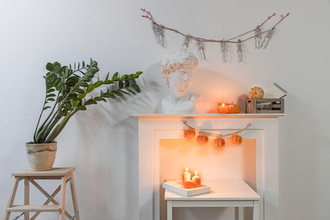 A garland of plastic pumpkins hangs from fireplace.