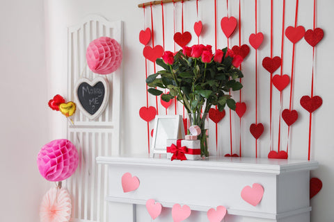 Bouquet of flowers on mantelpiece in room decorated for Valentine's Day.