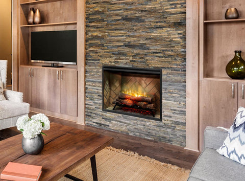 Electric fireplace insert in living room on stone wall.