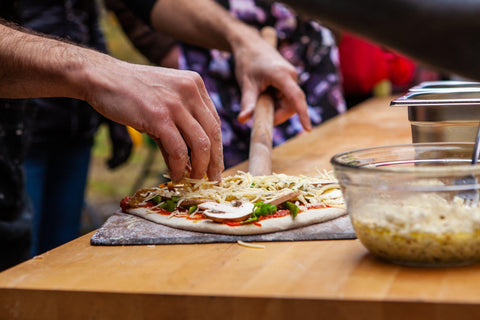 Man is adding dressings on his freshly kneaded pizza dough