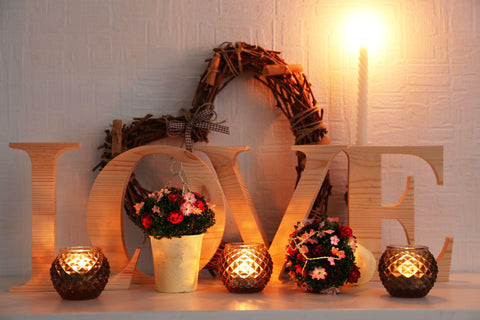 Romantic mantel with wicker heart and candle lights.