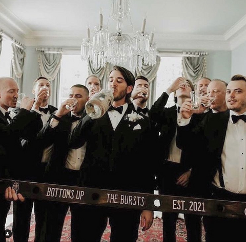 Groom and groomsmen taking a shot on the wedding day.