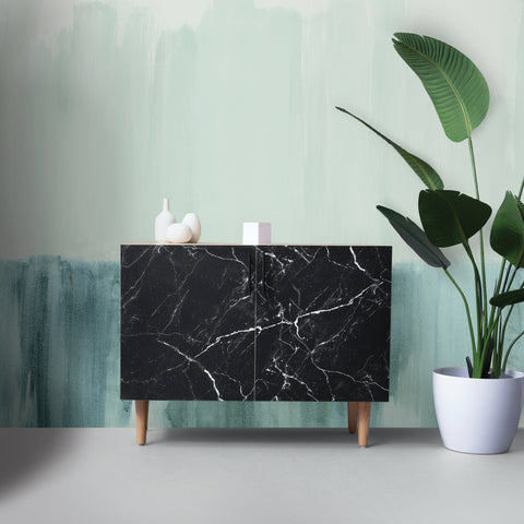 A oversized mural called Abstract Landscape was placed behind a small black console cabinet and plant.