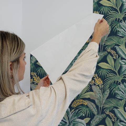 Girl removing Havana Palm removable wallpaper