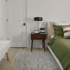 white and black Peppered Spots wool rug in a bedroom
