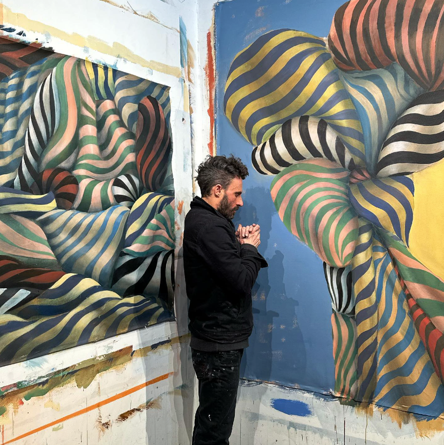 Artist Christopher Cuseo standing with painting.